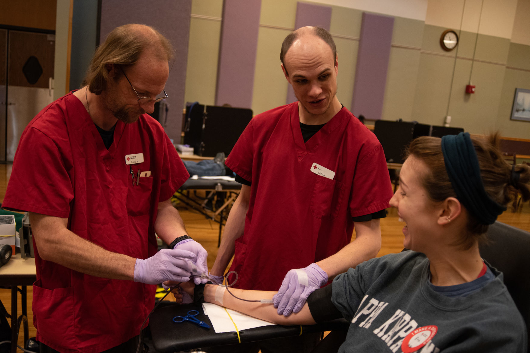 Erin Payne gives blood drive while being administered by Logan Minor, right, and David McDaniel,
